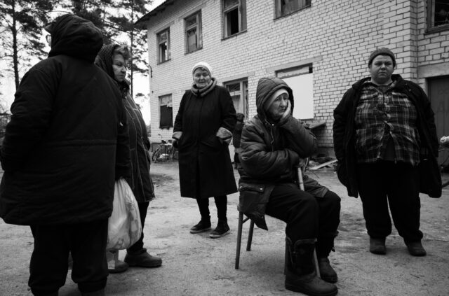 A group of women standing and sitting, waiting gathering and talking about their experiences after 40 days of Russian occupation, Yahidne, Ukraine - 14/04/2022.