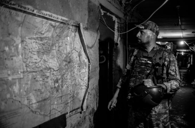 Member of Ukrainian Military unit in front of a map of the region in an underground shelter on the frontline near Kherson.