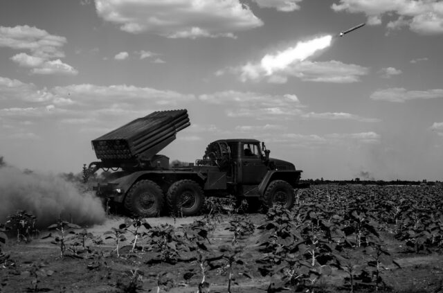 Ukranian Grad artillery (multiple rocket launcher) firing missiles - in a field for agriculture and farming - on Russian targets for defense operations of the 59th Brigade.