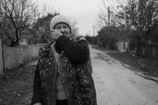 A woman cries in the street while watching special units take care of the deceased and Ukrainian military.