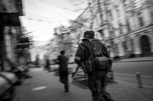 armed forces in the streets of Kyiv, running with weapons ready.