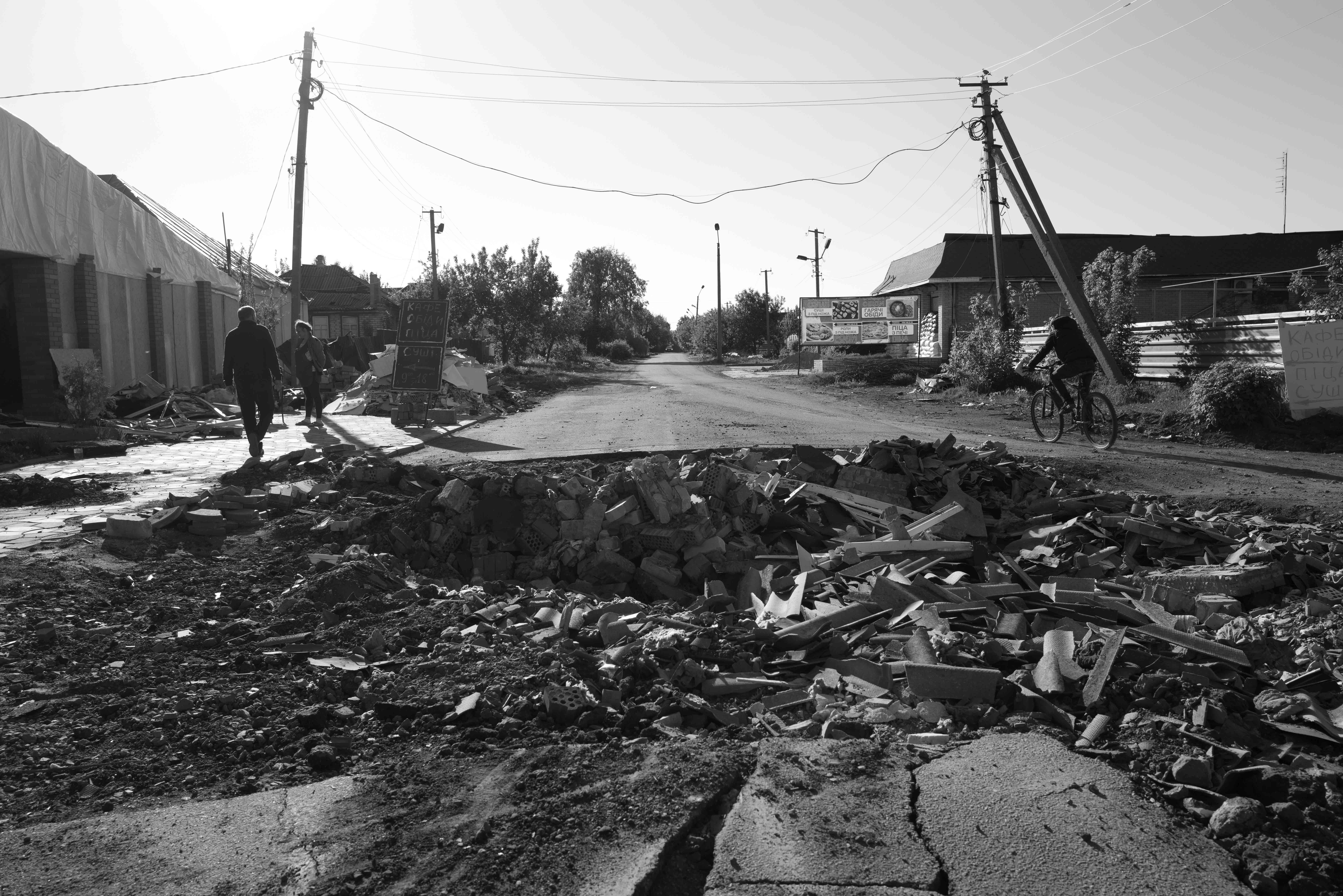 Borova, Kharkiv Oblast, Izium region - This town twenty kilometers from the frontline is cunder constant shelling daily. A caffe bar in front of an artillery hole in the street from a few days ago remains open.